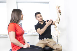 Maryland Chiropractor Treatment - man holding spine model describing to patient