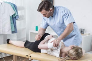 male chiropractor stretching female patient's back
